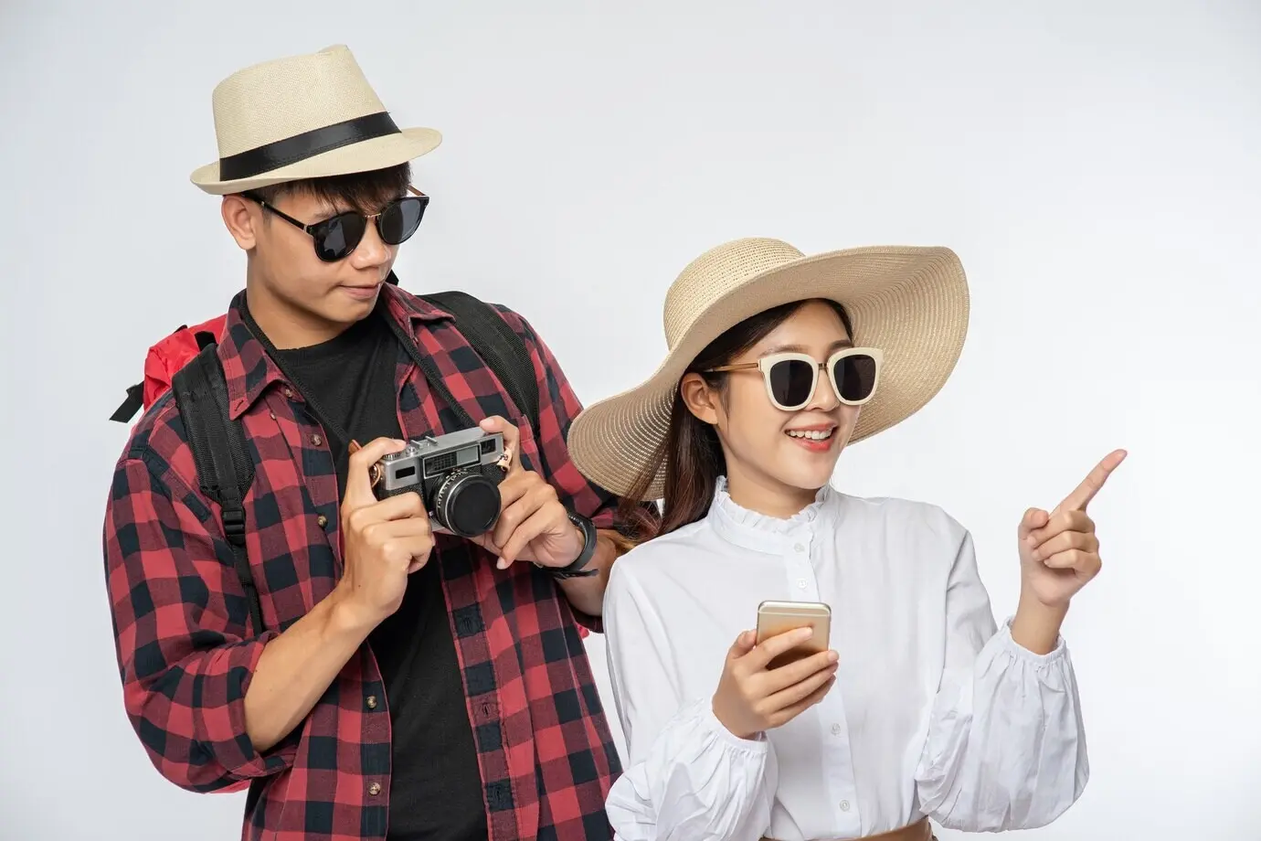 여행할 차림의 남녀가 안경을 쓰고 사진을 찍는다.